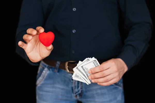 Banknotes of money and a red heart in the hands of a man — Stock Photo, Image