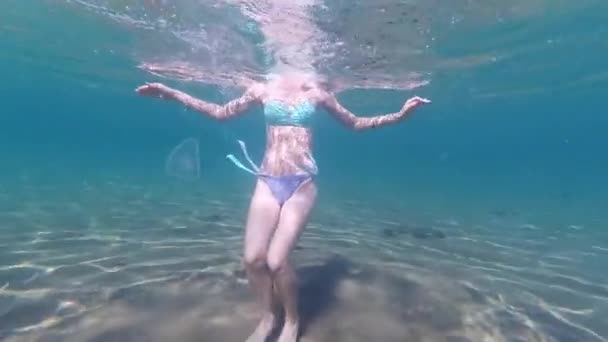 Юная стройная девушка весело танцует и плавает на песчаном побережье — стоковое видео