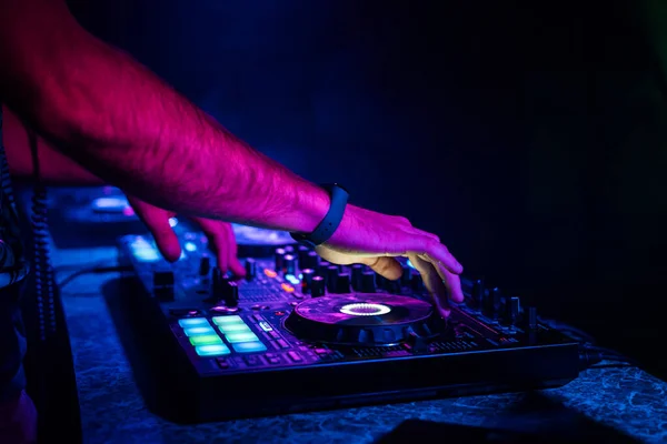 Hands of a DJ mixing music on a professional controller in a booth — Stock Photo, Image