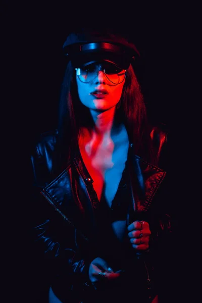 Fashion portrait of a stylish sexy girl with glasses in a leather jacket and cap — Stock Photo, Image