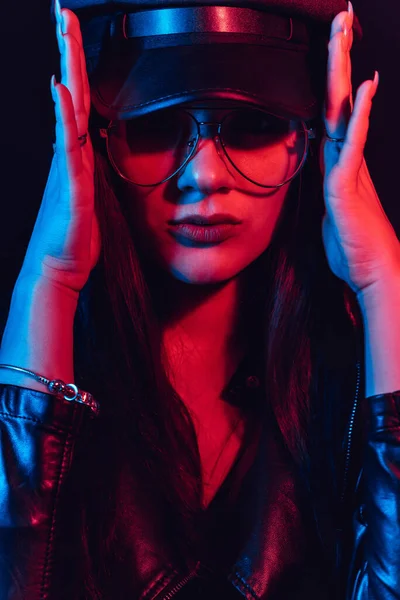 Fashion portrait of a stylish sexy girl with glasses in a leather jacket and a cap — Stock Photo, Image