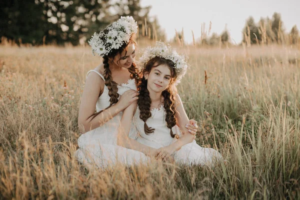 Feliz mãe e filha sorrindo e abraçando a grama no campo no verão — Fotografia de Stock