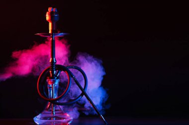 Siyah arka planda üzerinde metal bir kase olan cam nargile shisha.