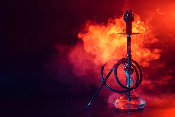 Narguilé shisha com frasco de vidro e tigela de metal com fumaça colorida em um fundo preto — Fotografia de Stock