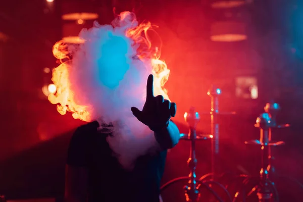 Homem fuma um narguilé e deixa sair uma nuvem de fumaça — Fotografia de Stock