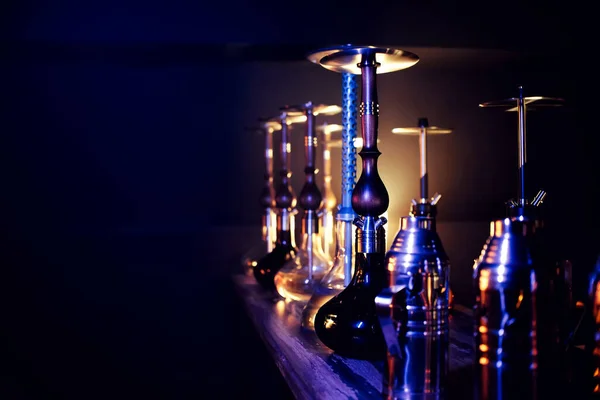 Många hookahs med shisha glasflaskor och metallskålar — Stockfoto
