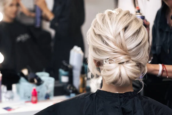 Penteado pão na cabeça da menina loira. Preparação para o dia do casamento no salão de beleza — Fotografia de Stock