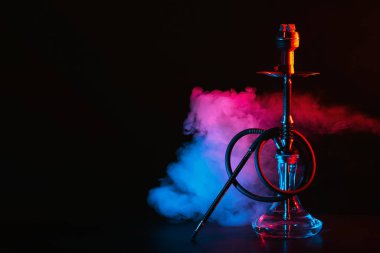 Cam mataralı nargile ve masada renkli dumanlı metal kase shisha.
