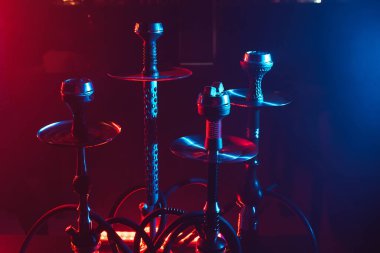 Geleneksel Arap rahatlaması için restoranın masasındaki tabakta shisha kömürlü hookahlar.