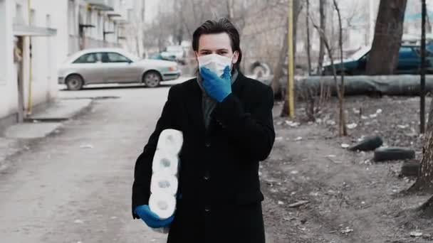 Больной человек кашляет в респираторной медицинской маске и перчатках для защиты от коронавирусной эпидемии COVID-19 — стоковое видео