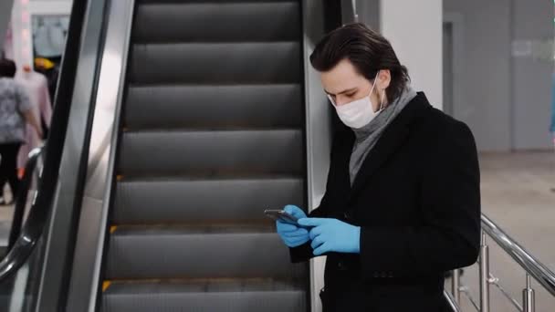 Man met een medisch masker en handschoenen ter bescherming tegen de COVID-19 coronavirus-epidemie en belt een mobiele telefoon — Stockvideo