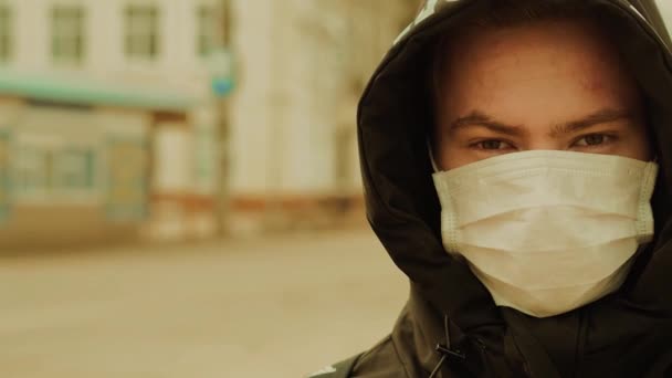 Epidemia to pandemia koronawirusa COVID-19. Młody facet w ochronnej masce medycznej od 2019-ncov — Wideo stockowe