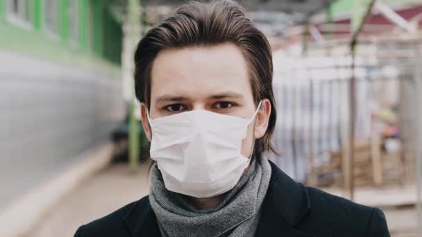 Человек в медицинской маске для защиты от эпидемии коронавируса COVID-19 — стоковое видео