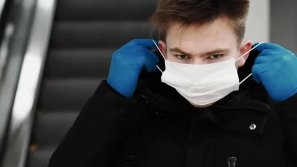 Tonåringen man sätter på en respiratorisk medicinsk mask för att skydda mot COVID-19 coronavirus — Stockvideo