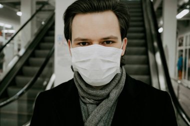 Kavram 2019-ncov coronavirüs. COVID-19 salgınından korunmak için tıbbi maske takan beyaz bir beyaz adamın portresi.