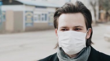 Sokaktaki Coronavirus COVID-19 'dan korunmak için solunum maskeli beyaz bir adam.