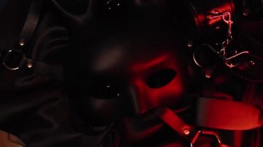 Seks dükkanından alınmış bir dizi erotik oyuncak. Maske, deri kemer, kelepçe ve kamçı.