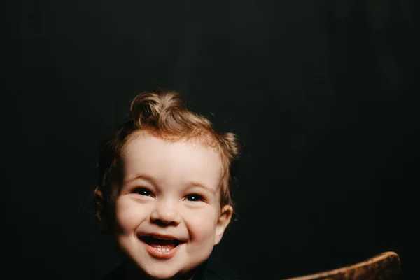 Egy boldog mosolygós kaukázusi kisfiú arca sötét háttérrel — Stock Fotó