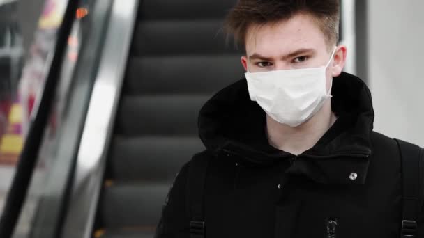 Joven con una máscara respiratoria médica para protegerse contra el coronavirus COVID-19 — Vídeos de Stock