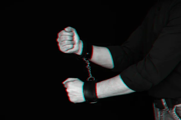 Mens hands chained in leather handcuffs on black background — Stock Photo, Image