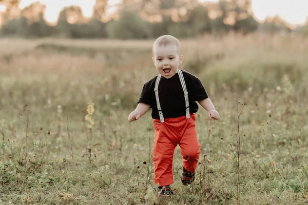Vicces kisfiú fut a nyári fű a mezőn — Stock Fotó
