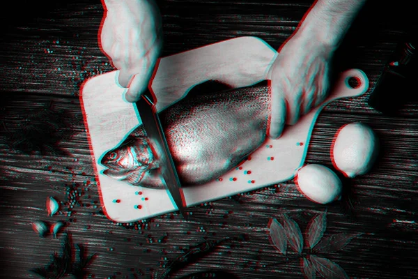 Séf kezek egy késsel halat vágnak egy fa asztalon a konyhában. Friss pisztráng — Stock Fotó