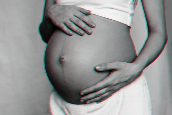 W ciąży dziewczyna przytula jej brzuch z jej ręce zbliżenie — Zdjęcie stockowe