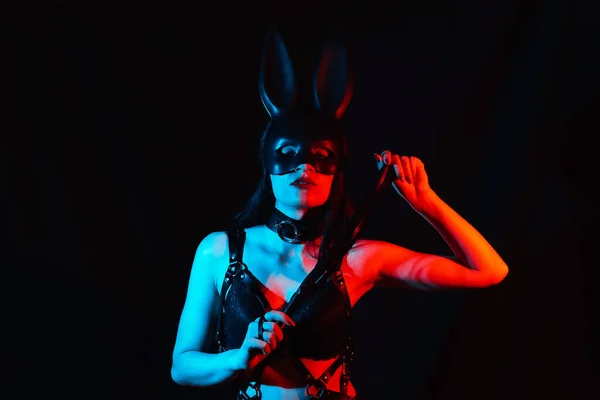 Portrait de fille sexy dominatrice masqué lapin en cuir harnais avec fouet — Photo