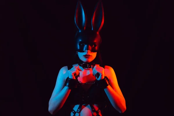 Chica sumisa en máscara de conejo y arnés de cuero en esposas de cuero — Foto de Stock