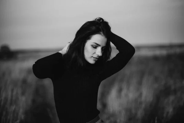 Black and white portrait of a young girl posing Caucasian brunette girl in a sweater — Stock Photo, Image