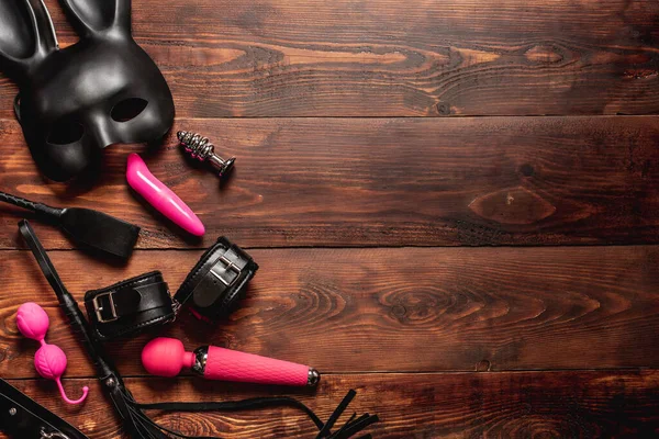 Silicone vibrator and vaginal balls, leather whip and handcuffs with mask and belt — Stock Photo, Image