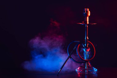 Cam mataralı nargile ve masada renkli dumanlı metal kase shisha.