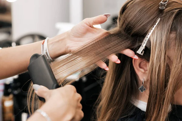 Cabeleireiro cria volume e estilo para cabelos castanhos em uma cabeça de mulher — Fotografia de Stock
