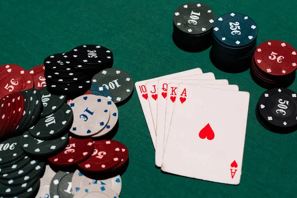 Winning a game of poker at the casino. Royal flush and a Bank of chips on the background of the green table — Stock Photo, Image