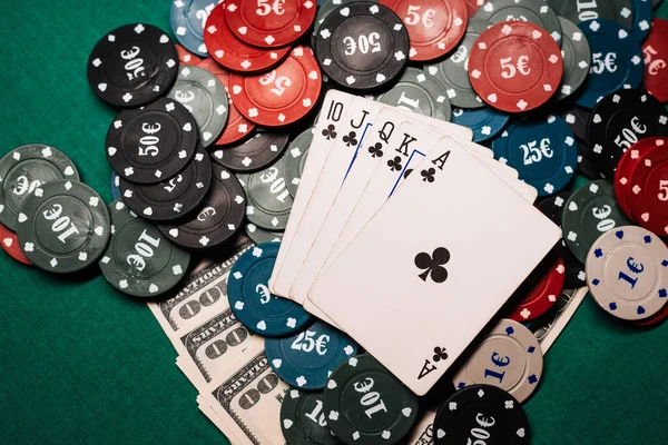 Winnende combinatie van kaarten in casino poker. Royal Flush, een hoop chips en geld dollars. — Stockfoto