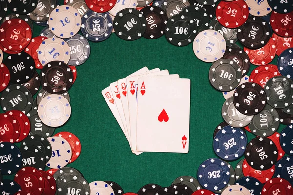 Royal flush op de achtergrond van gaming chips op de groene tafel in het casino — Stockfoto