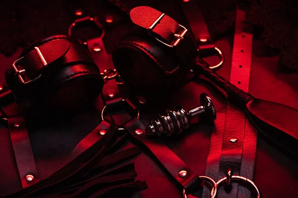 Set para sexo BDSM en la tienda. Látigo de cuero y esposas con gargantilla y plug anal — Foto de Stock