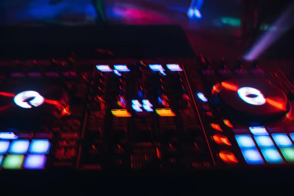 DJ mixer em uma boate com um fundo de luzes brilhantes de botões — Fotografia de Stock