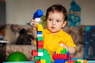 Mutlu çocuk bloklardan ev yapmayı öğreniyor.