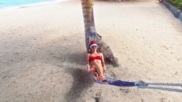 Mladá žena v santa hat ležet na pláži. Vánoční prázdniny. Vánoční beach dovolená cestování žena nosí Santa čepice a bikinách se těší na Vánoce na tropické pláži.