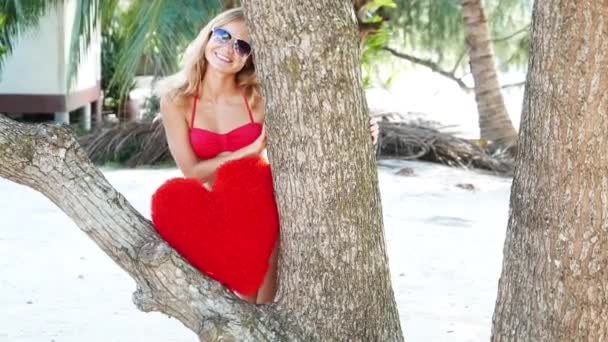 Krásná žena v červené bikiny na pláži u moře. Mladý Roztomilý dospívající dívka s hračkou srdce. Ostrov.