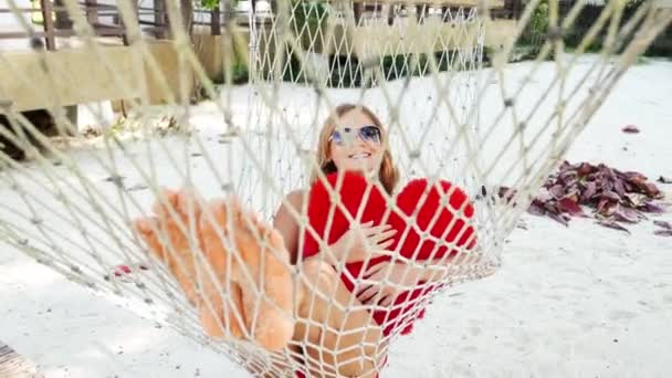 Kadın, Samui Adası, Tayland tropik sahilde hamakta. Güzel yuong kız sahilde oyuncak ile döşeme. Kırmızı bikini ve Güneş gözlükleri. — Stok video