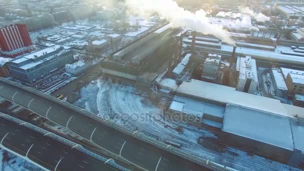 ロシアの大都市の工業地域の空撮。高速道路と日没の燻製工場. — ストック動画