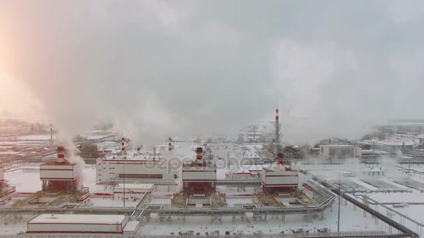 Вид с воздуха на нефтяную электростанцию. Холодный зимний день. Сияние солнца . — стоковое видео