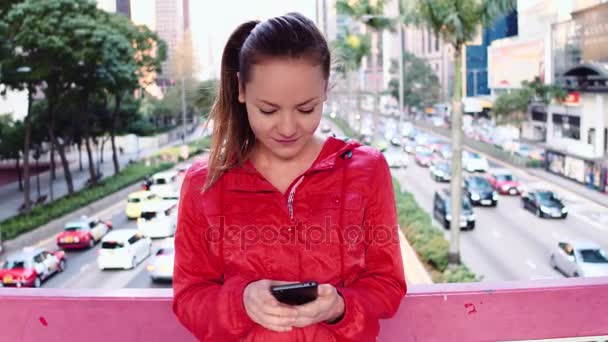 Jonge brunette vrouw met behulp van de telefoon in de Hong Kong stad. — Stockvideo