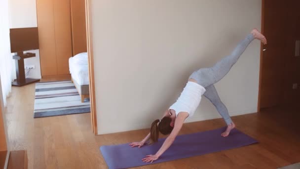 Zdolna kobieta uprawiająca jogę na macie w domu, w sypialni. koncepcja stylu życia — Wideo stockowe