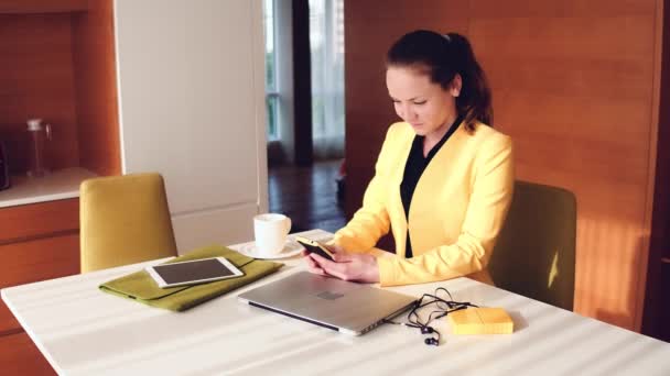 Mujer joven con chaqueta amarilla usando el teléfono . — Vídeos de Stock