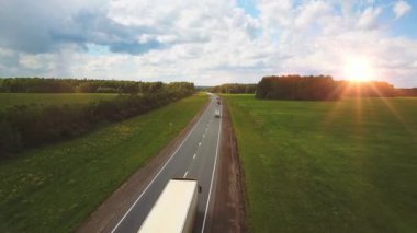 Güzel bir manzara, otoyolda bir gezinti kamyonlar ve gün batımında birkaç araba. hava görünümü