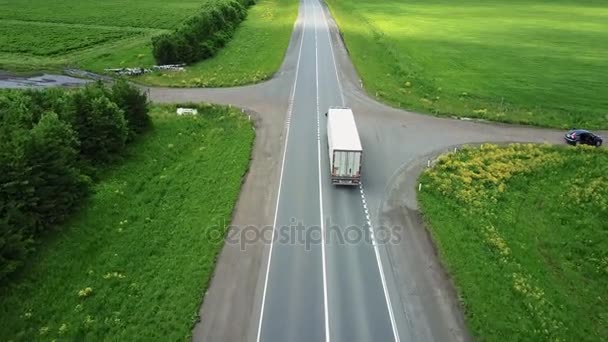 Пейзаж с ездой по шоссе грузовиков и нескольких легковых автомобилей на закате. вид с воздуха — стоковое видео