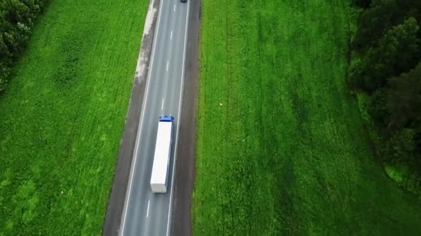 Camions de livraison conduisant vers le soleil. Vue aérienne f champs verts snd camions — Video